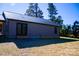 Rear view of home showcasing gray metal siding, black metal roof, and double doors at 411 E Gary St, Candor, NC 27229