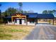 Gray metal siding home with black metal roof, covered porch, and carport at 411 E Gary St, Candor, NC 27229