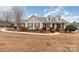 Beige house with gray roof, landscaping, and a walkway at 4426 Appaloosa Ln, Charlotte, NC 28215