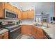 L-shaped kitchen with stainless steel appliances and wood cabinets at 6330 Rhodins Ln, Fort Mill, SC 29707