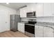 Modern kitchen with white cabinets, stainless steel appliances, and granite countertops at 103 Adams Tree Way, Troutman, NC 28166