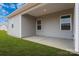 Covered patio with gray vinyl siding and grassy backyard at 167 Wembury Ln, Troutman, NC 28166