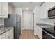 Kitchen with stainless steel refrigerator, white cabinets, and granite countertops at 171 Wembury Ln, Troutman, NC 28166