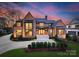 Stunning brick home featuring a manicured lawn, complemented by a well-lit, inviting entrance and tasteful landscaping at 2103 Cortelyou Rd, Charlotte, NC 28211