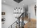 Elegant staircase featuring a modern chandelier and metal railings at 2103 Cortelyou Rd, Charlotte, NC 28211