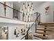 Modern staircase illuminated by a designer chandelier, showcasing architectural elegance and stylish design details at 2103 Cortelyou Rd, Charlotte, NC 28211