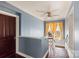 Upper hallway with wood floors, a ceiling fan, and yellow curtains at 302 S College St, Monroe, NC 28112