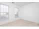 Well-lit bedroom with neutral walls and carpet, featuring two large windows with blinds at 4030 Garden Oak Dr, Indian Trail, NC 28079