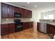 Kitchen features dark wood cabinets and black appliances at 4030 Garden Oak Dr, Indian Trail, NC 28079