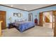 A calm bedroom has blue walls, wood trim, and doors leading to a bath and hall at 411 Major Run, Cramerton, NC 28032