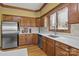Bright kitchen with wooden cabinets, stainless steel refrigerator, and a window providing natural light at 411 Major Run, Cramerton, NC 28032