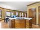 Open kitchen design with wooden cabinets, an island cooktop, and seamless flow into the dining and living areas at 411 Major Run, Cramerton, NC 28032
