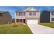 Two-story house with a red door and attached garage, fresh landscaping at 5149 Fireweed Ct, Dallas, NC 28034