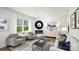 Living room with hardwood floors, gray sofas, fireplace, and large windows at 5149 Fireweed Ct, Dallas, NC 28034