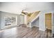 Bright living area with hardwood floors, featuring a view of the front yard and a staircase at 6303 Windsor Gate Ln, Charlotte, NC 28215