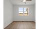 Bright, empty bedroom with hardwood floors and a large window offering a view of the outdoors at 8078 Blackwood Rd, Denver, NC 28037