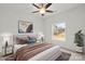 This staged bedroom has a neutral color scheme with a ceiling fan and a window view at 8078 Blackwood Rd, Denver, NC 28037