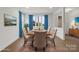 Elegant dining room with hardwood floors, a classic rug, and beautiful blue curtains at 8078 Blackwood Rd, Denver, NC 28037