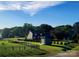 A lovely home with a sprawling green yard and storage building is surrounded by mature trees under a bright sky at 8078 Blackwood Rd, Denver, NC 28037