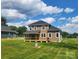 Beautiful backyard showcases a spacious porch and a lovely green yard under a partly cloudy sky at 8078 Blackwood Rd, Denver, NC 28037