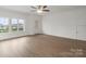 Spacious living room with light wood floors, a ceiling fan, and natural light from large window at 8078 Blackwood Rd, Denver, NC 28037