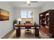 Home office featuring a large wooden desk, bookshelves, and a comfortable chair perfect for productivity at 8078 Blackwood Rd, Denver, NC 28037