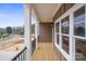 Inviting covered porch with wood flooring, black railing and white pillars offers scenic neighborhood views at 8078 Blackwood Rd, Denver, NC 28037