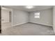 Bright bedroom featuring neutral walls and grey carpet at 109 Belton Ave, Mount Holly, NC 28120
