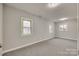 Spacious bedroom with two windows and grey carpet at 109 Belton Ave, Mount Holly, NC 28120