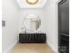 Elegant entryway with a large circular mirror and modern console table at 130 Cherokee Rd # 304, Charlotte, NC 28207