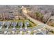 Aerial view showcasing the home's location with nearby road, wooded area and other homes at 2006 Houle Ln, Charlotte, NC 28214