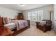 Inviting bedroom boasts a comfortable bed, chair, dresser, and natural light from the large windows at 2006 Houle Ln, Charlotte, NC 28214