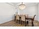 Bright dining room with a crystal chandelier, wood floors, wainscoting, and dining table with chairs at 2006 Houle Ln, Charlotte, NC 28214