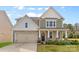 Charming two-story home featuring stone accents, attached two car garage and covered front porch at 2006 Houle Ln, Charlotte, NC 28214