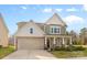 Charming two-story home featuring stone accents, attached two car garage and covered front porch at 2006 Houle Ln, Charlotte, NC 28214