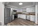 Well-lit kitchen with stainless steel appliances, white cabinetry, and stylish flooring at 203 Riverview Ter, Clover, SC 29710