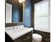 Elegant powder room with dark blue walls, gold trimmed mirror, and a white vanity at 2530 Park Rose Ln # 12, Charlotte, NC 28204