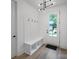 Bright entryway with coat hooks, bench, storage, and wood look flooring at 2530 Park Rose Ln # 12, Charlotte, NC 28204