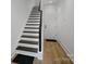 Modern staircase with dark wood steps, white risers, and wood-look flooring at 2530 Park Rose Ln # 12, Charlotte, NC 28204