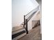 Modern staircase with dark metal railing and wood stairs, providing access to upper levels at 2530 Park Rose Ln # 12, Charlotte, NC 28204