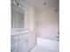 Bright bathroom features white cabinets, tile surround shower-tub, and modern fixtures at 2534 Park Rose Ln # 11, Charlotte, NC 28204