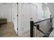 Bright hallway with modern black railing, and white doors, leading to additional rooms in the house at 2534 Park Rose Ln # 11, Charlotte, NC 28204