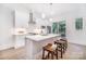 Modern kitchen with white cabinets, a stainless steel range hood, and an island with bar stool seating at 2534 Park Rose Ln # 11, Charlotte, NC 28204
