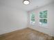 Light-filled bedroom with hardwood floors and two windows offering bright natural light at 2538 Park Rose Ln # 10, Charlotte, NC 28204