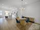 Open-concept dining room with modern chandelier and a view into the kitchen featuring stainless steel appliances at 2538 Park Rose Ln # 10, Charlotte, NC 28204