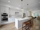 A spacious kitchen with white cabinets, stainless steel appliances, and a large island with seating at 2538 Park Rose Ln # 10, Charlotte, NC 28204