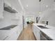 Modern kitchen featuring white cabinetry, stainless steel appliances, a large island and view to the dining and living area at 2538 Park Rose Ln # 10, Charlotte, NC 28204