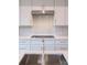 Modern kitchen boasts sleek white cabinets, subway tile backsplash, and stainless steel range hood at 2538 Park Rose Ln # 10, Charlotte, NC 28204