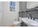 Small powder room with a pedestal sink and gray-toned wall paneling at 3113 Colyer Pl, Charlotte, NC 28205