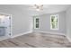 This bedroom has gray hardwood flooring, neutral walls, two windows and a ceiling fan at 4251 Candlewood Dr, Sherrills Ford, NC 28673